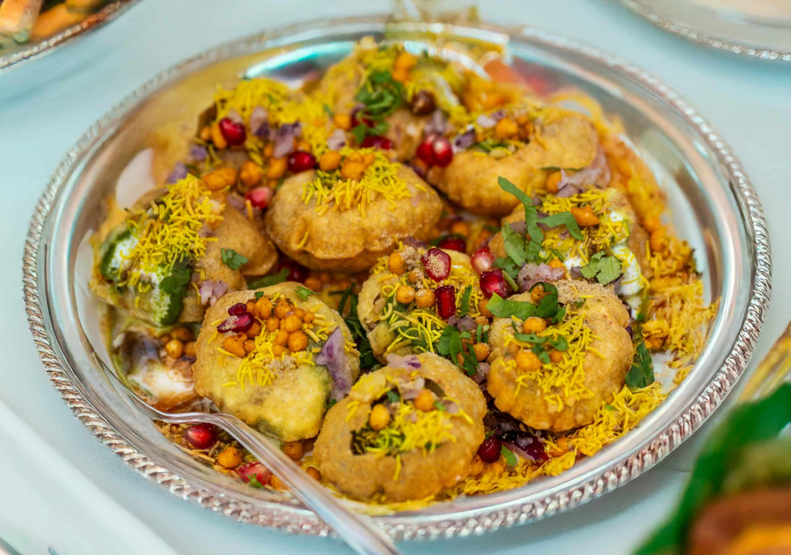 Tempting plate of crunchy Pani Puri topped with colorful garnishes.